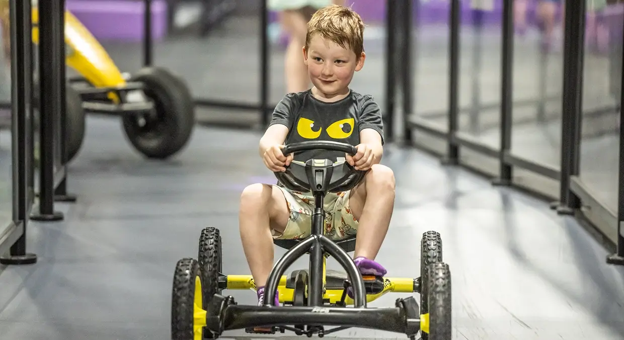 A young boy enjoys the speed of the Pedal Car Track at SuperPark