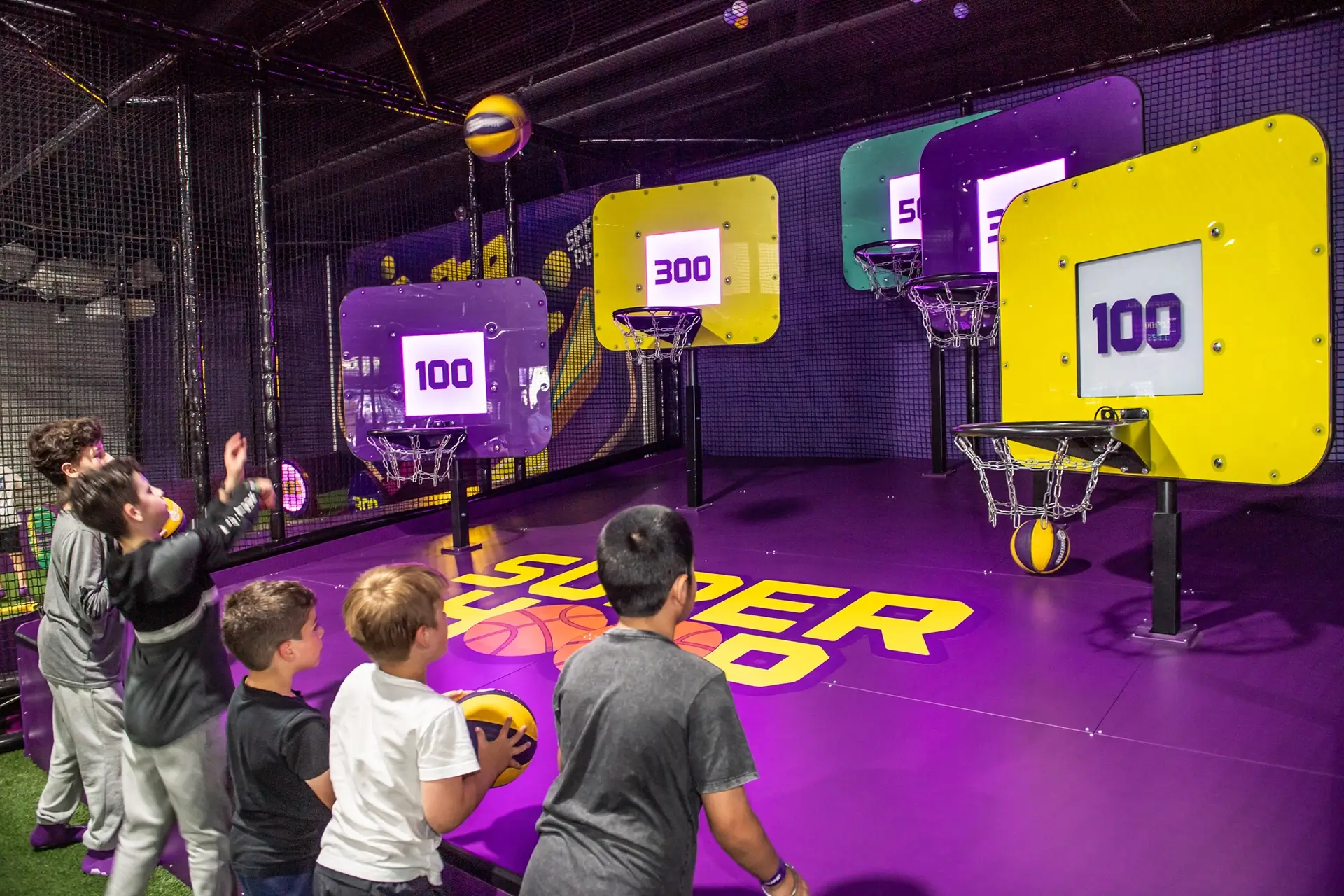 A group of happy kids play SuperHoop indoor basketball