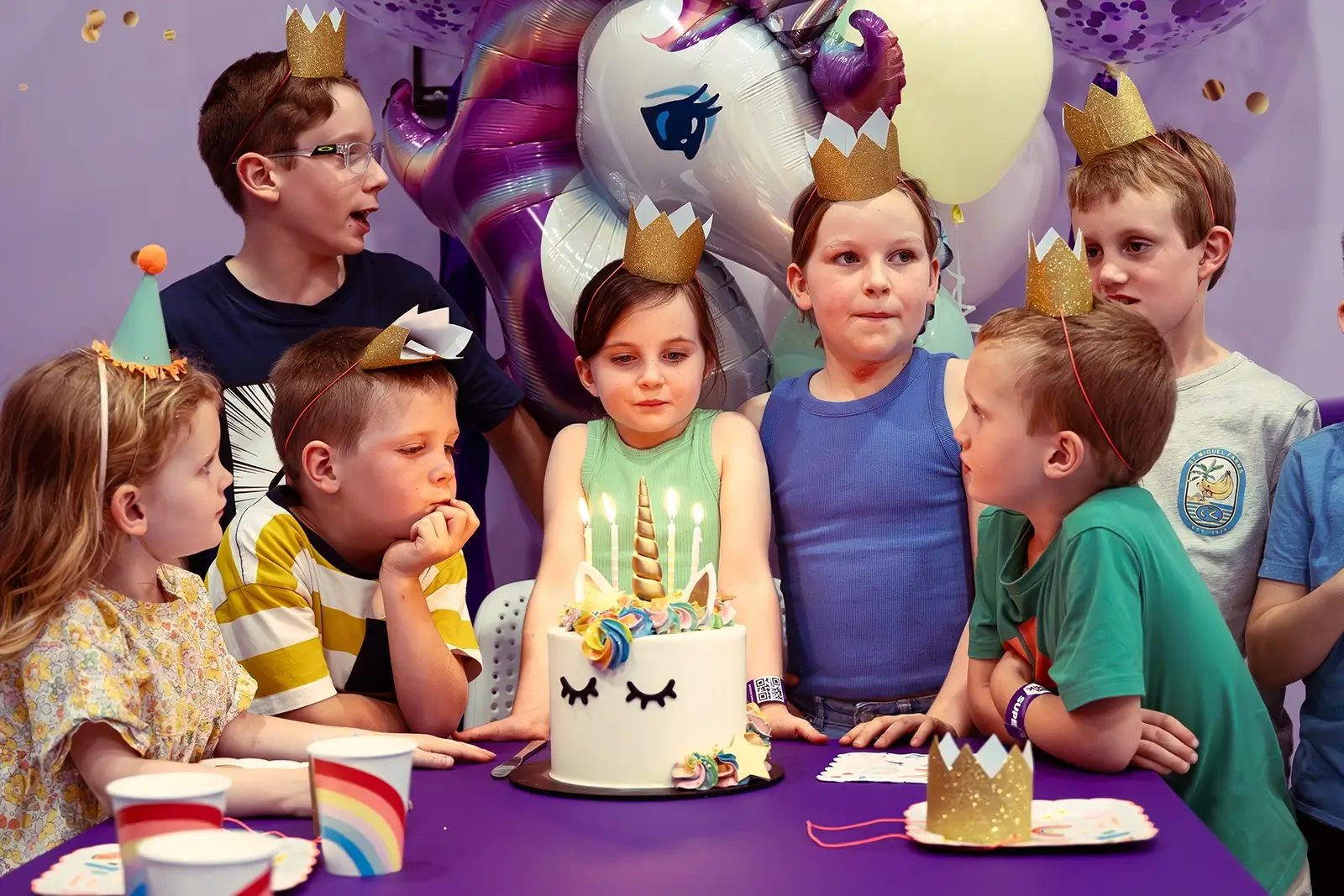 Kids surround a birthday cake with candles in Melbourne