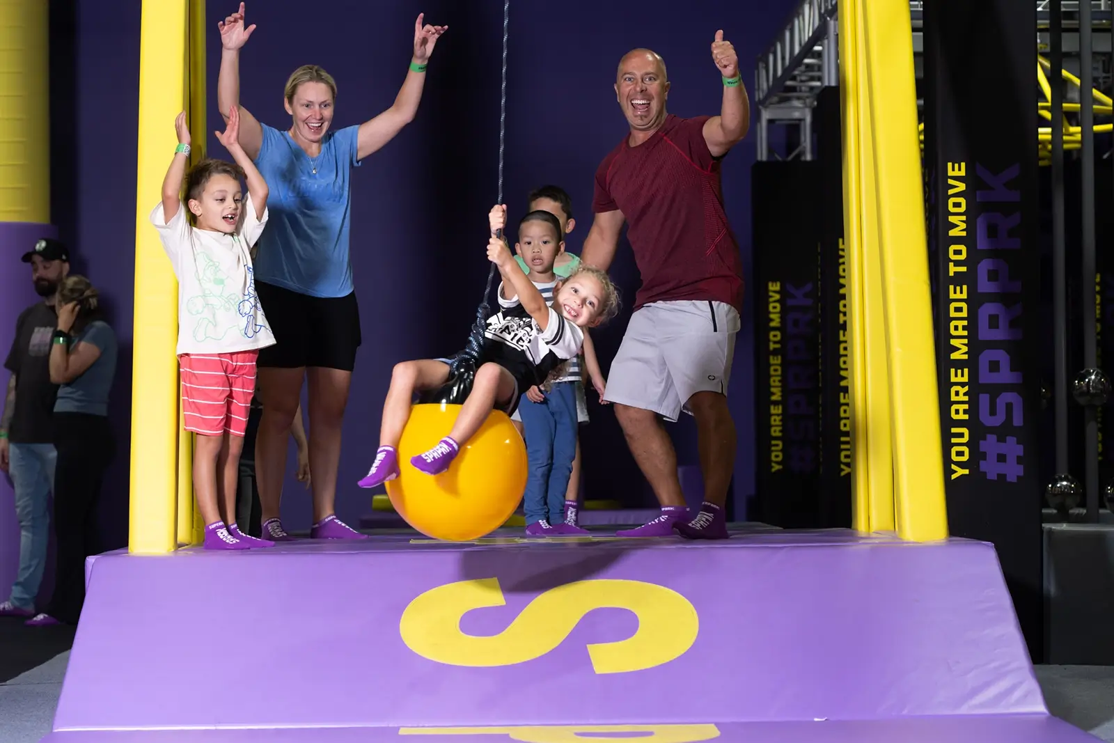 Young family having fun with kids at indoor playground