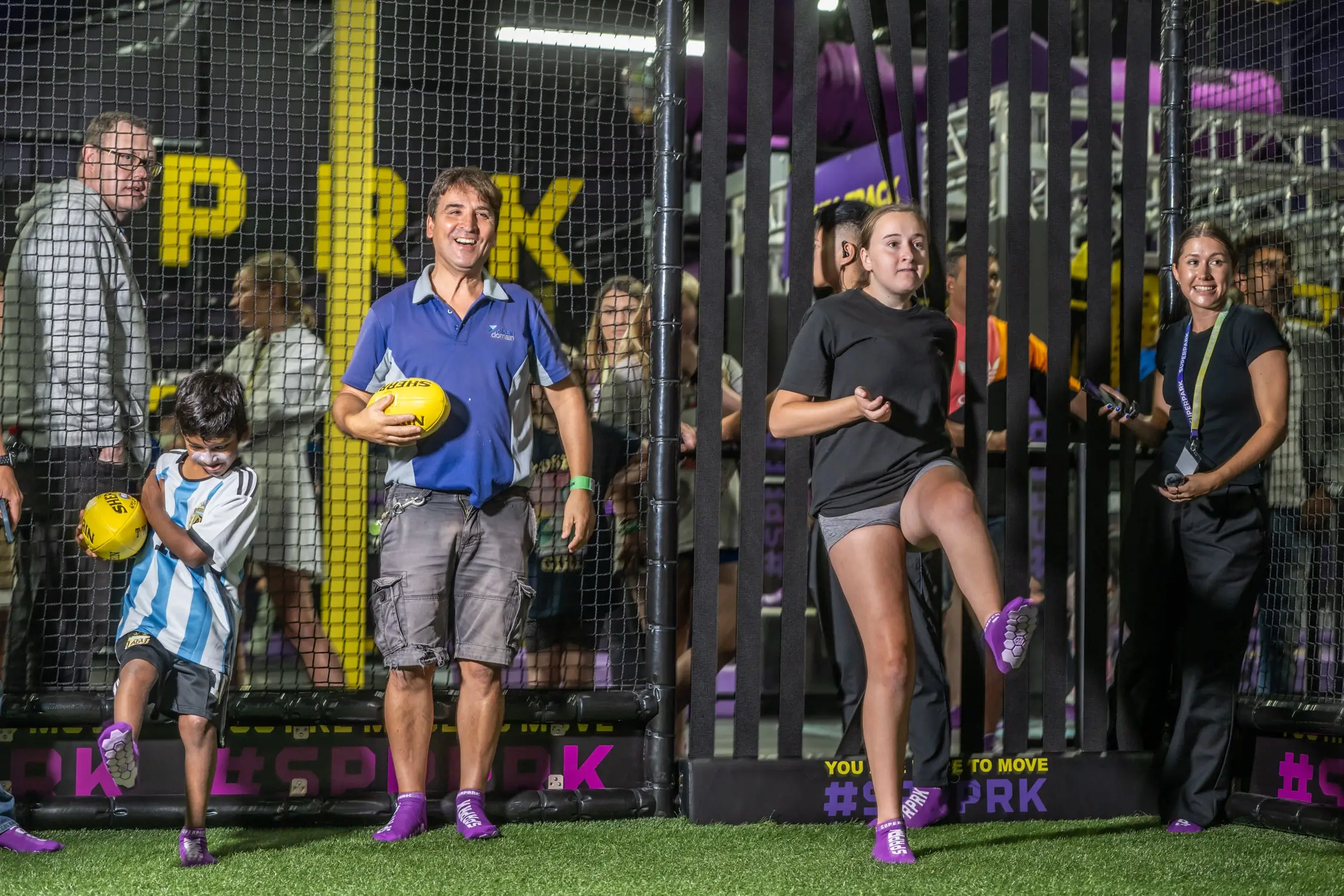 Father and daughter play SuperFooty at indoor playground