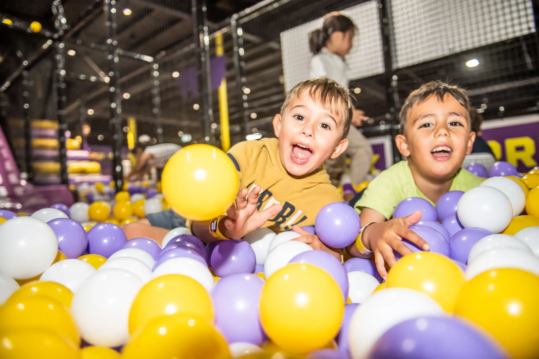 Two kids play in a ball pit in school holidays at SuperPark