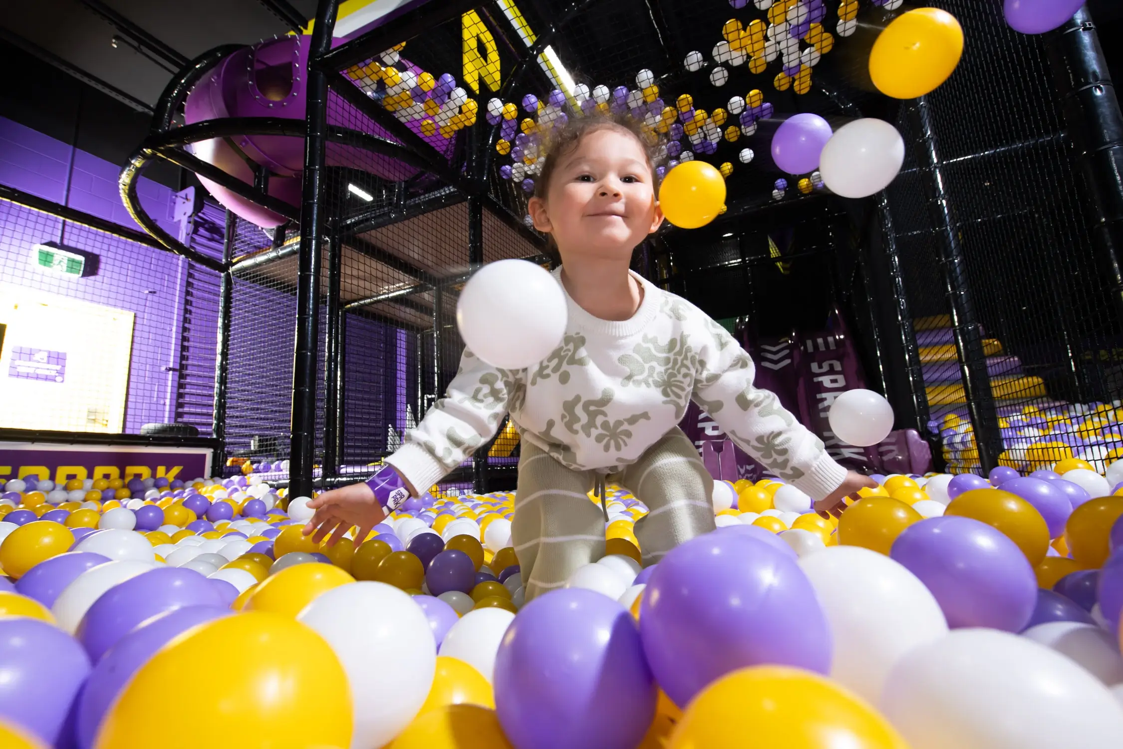 Young girl plays in the ball pit at SuperPark