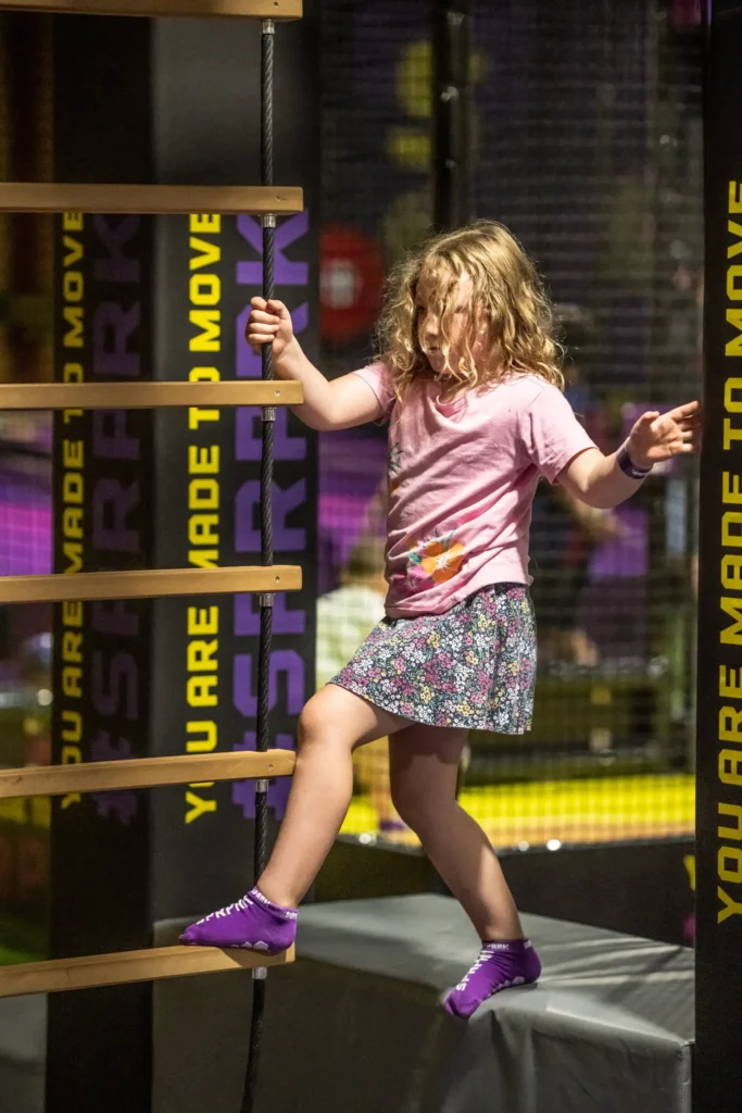 A little girl playing in a ninja themed play area