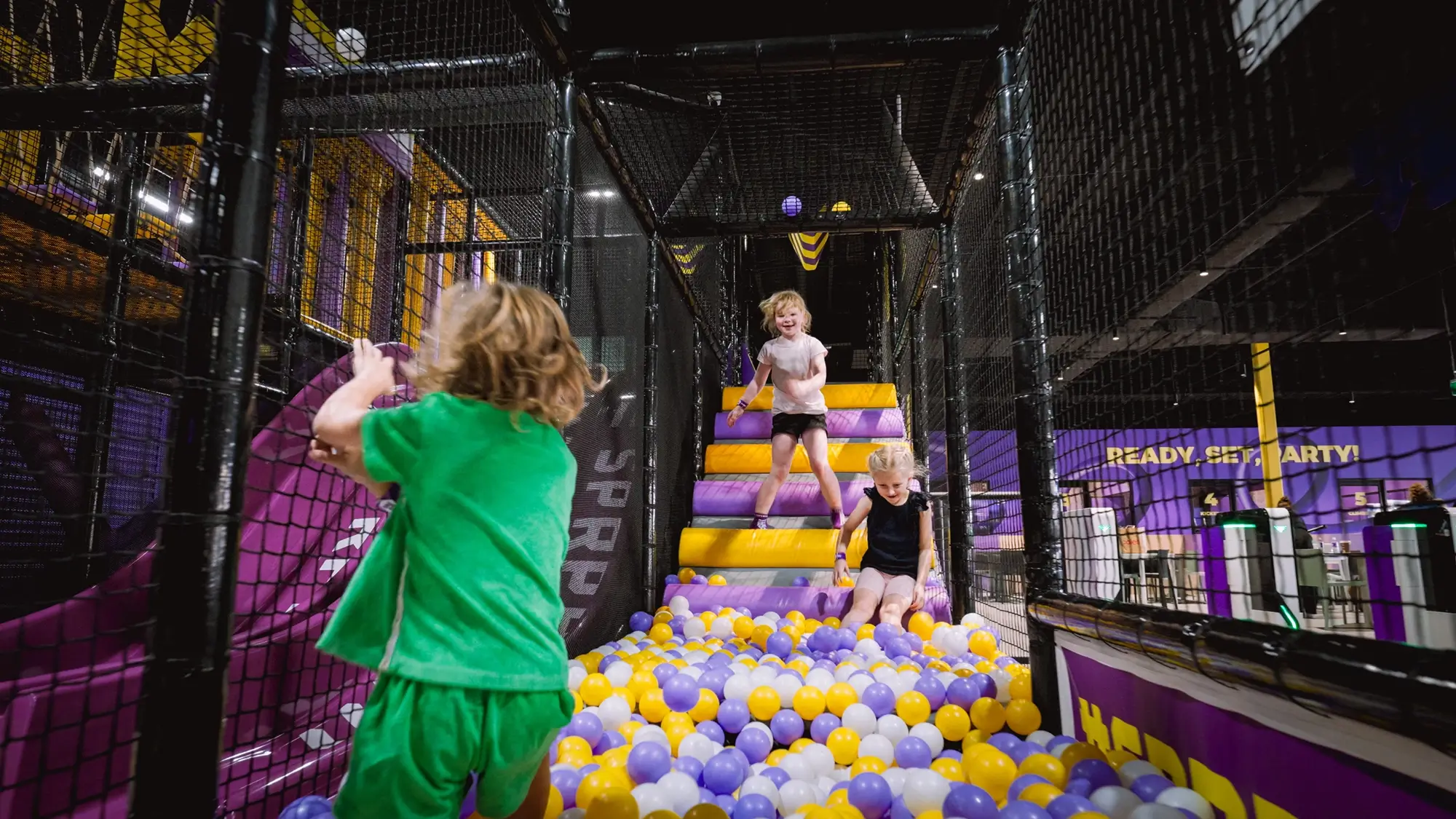 Three young children engaging in school holiday entertainment