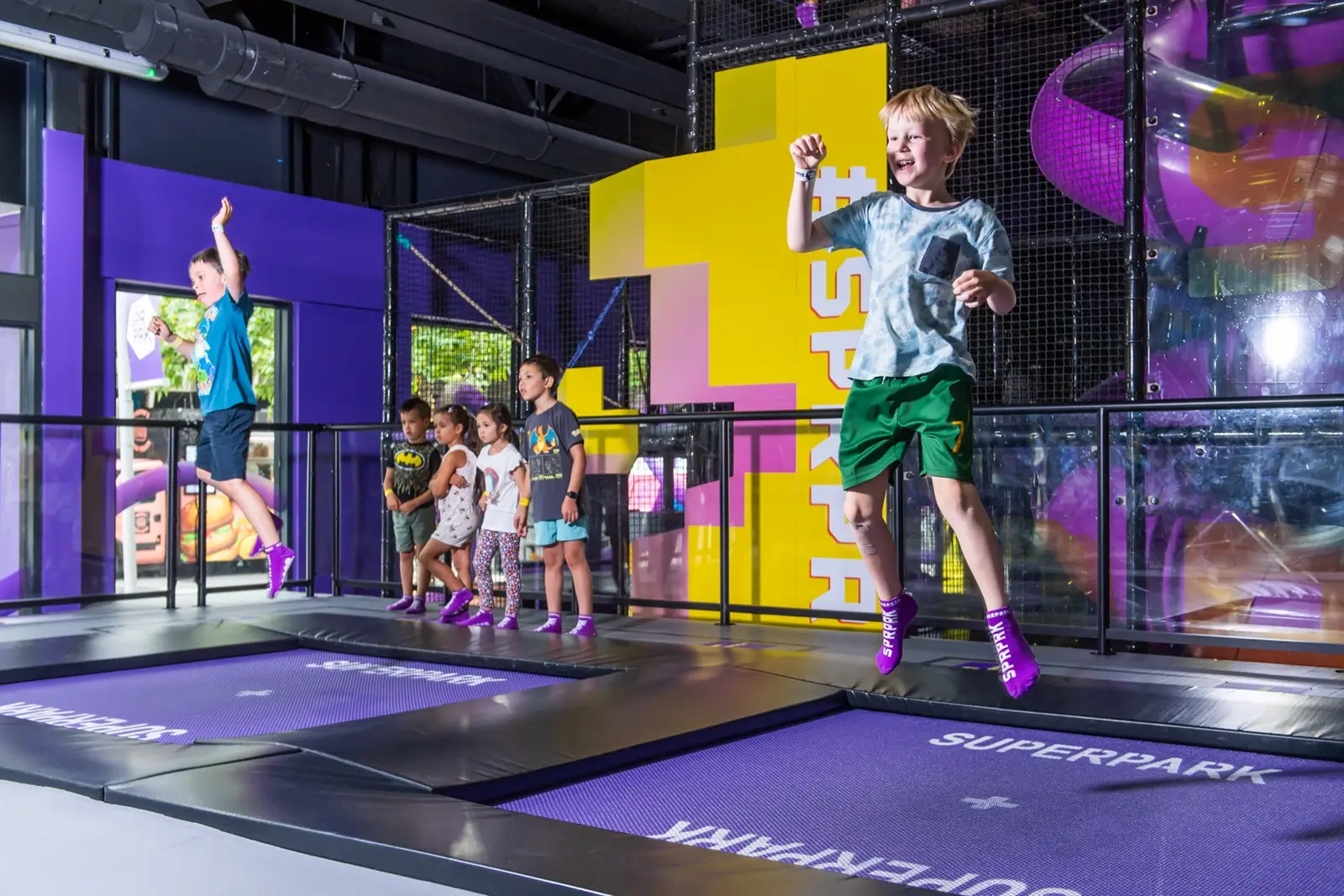 Two young boys jumping in a trampoline park