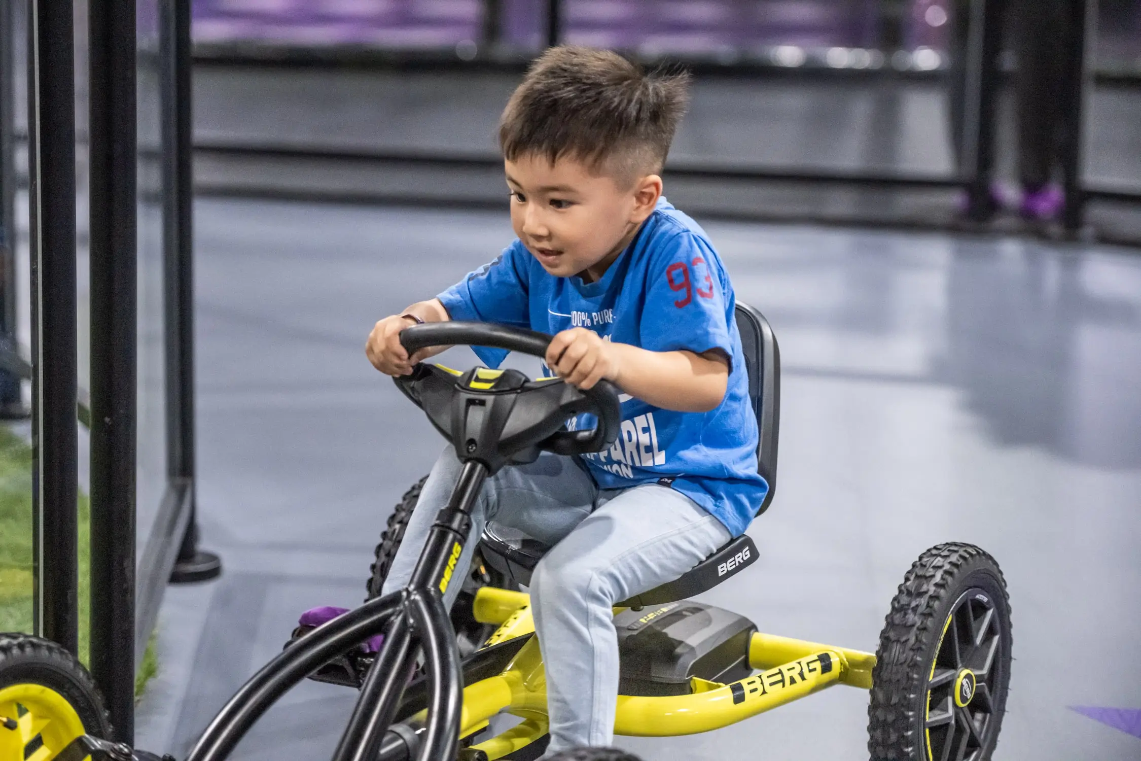 Young boy concentrates on the indoor Pedal Car Track